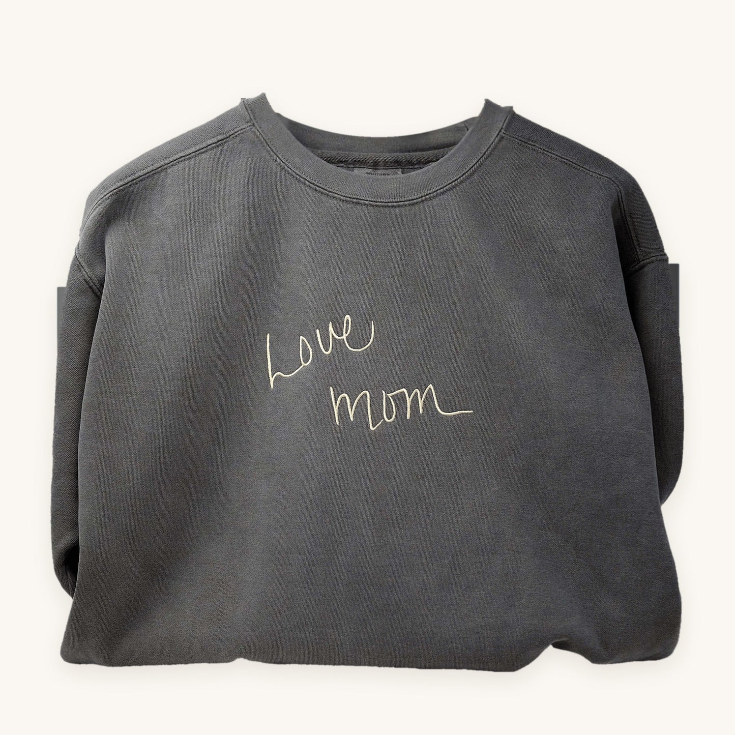 A loved one's handwriting embroidered on a grey crewneck sweatshirt