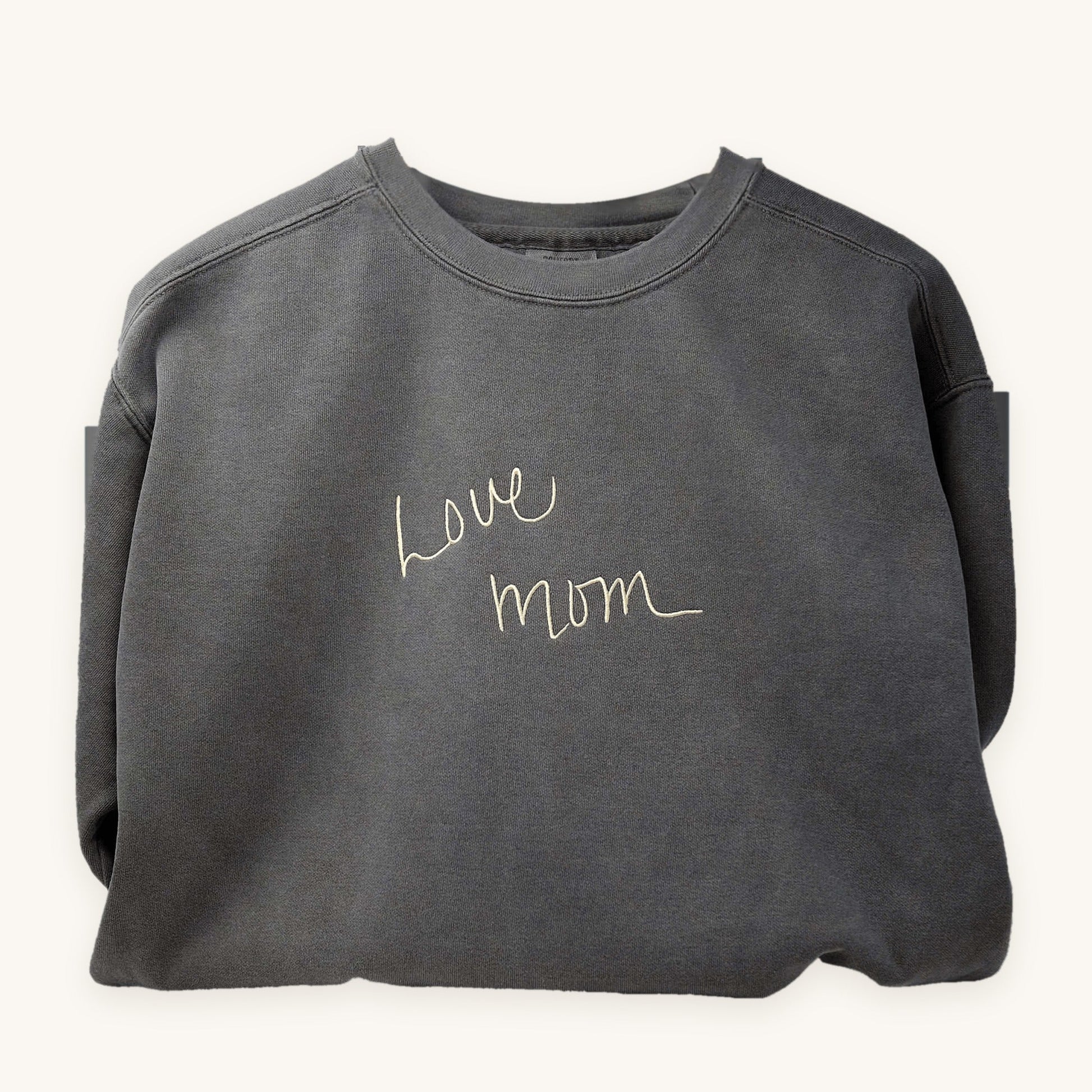 A loved one's handwriting embroidered on a grey crewneck sweatshirt