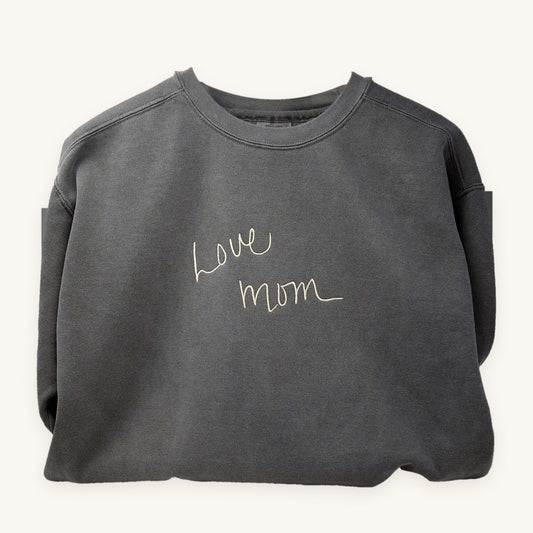 A loved one's handwriting embroidered on a grey crewneck sweatshirt