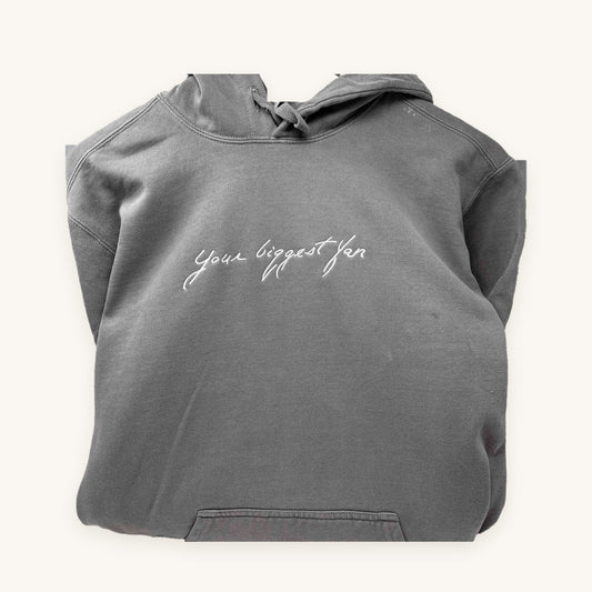 A loved one's handwriting embroidered on a grey hoodie